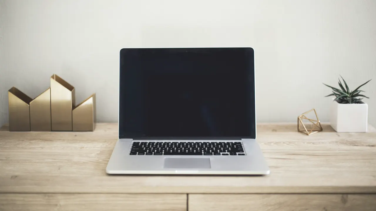 Escritorio con una notebook abierta y un espacio de trabajo ordenado