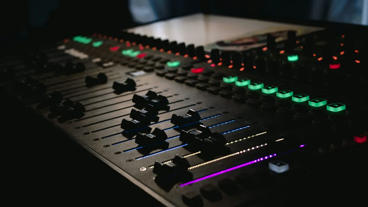 Consola de mezcla de radio iluminada en un estudio en penumbra